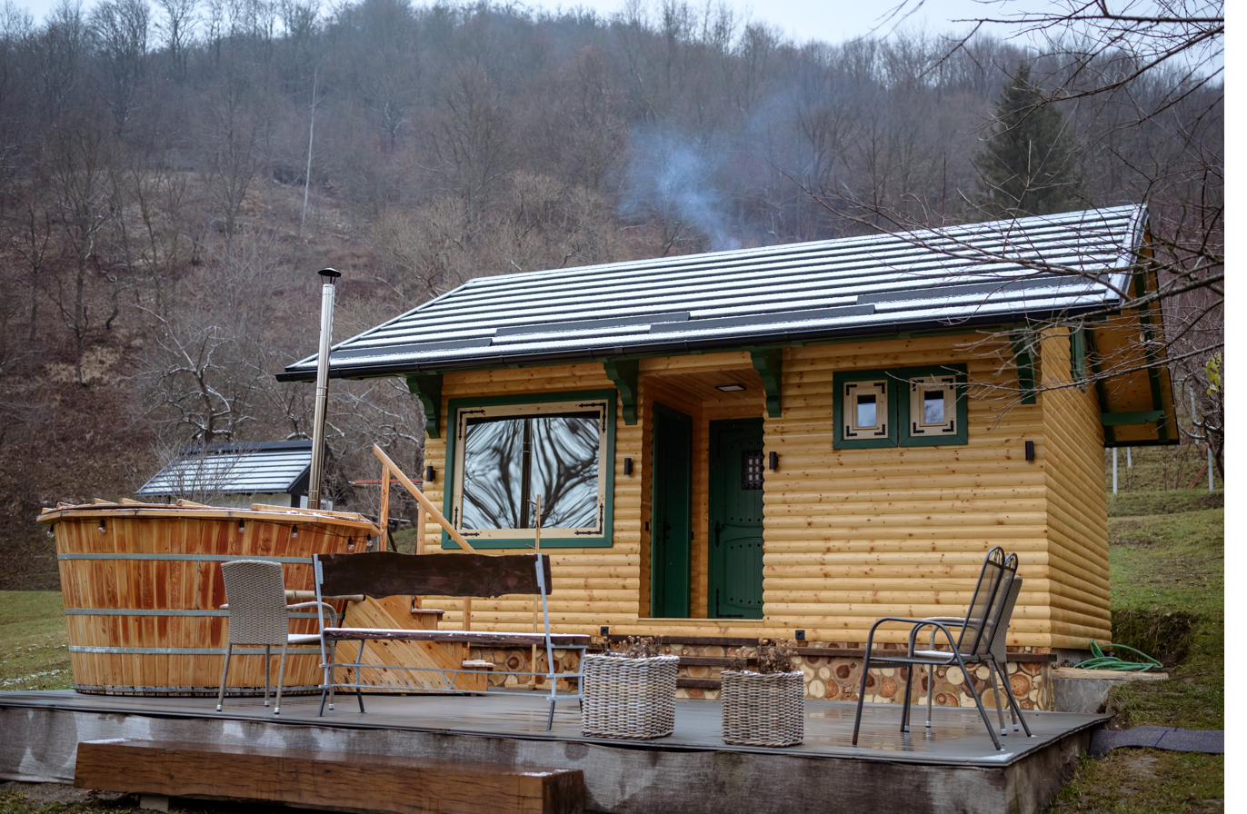 Cabana de saună și ciubărul pe terasă, cu fum ieșind pe horn, iarna